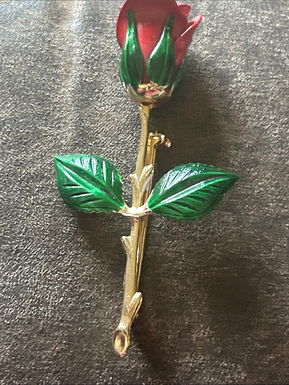 Gold tone red rose brooch.